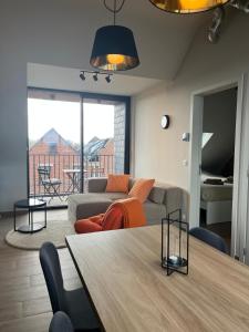a living room with a couch and a table at Bomaison charmant landelijke studio in Aalter