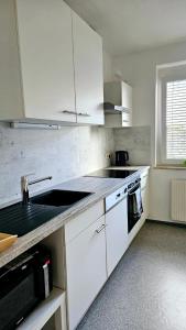 a kitchen with white cabinets and a sink and a stove at Cozy, new, central in Graz