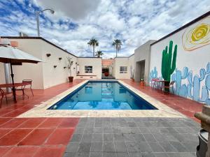 a swimming pool in front of a building with a mural at Hotel Buen Valle in Torreón