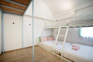 a bedroom with two bunk beds and a ladder at Green Group Hotel & Pool Bangkok Old Town in Bangkok