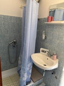 a bathroom with a shower curtain and a sink at Apartments Bilić in Vis +58 photos