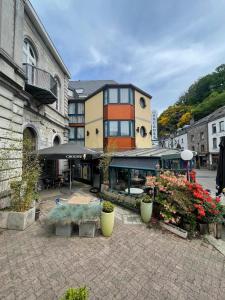 a building with plants and flowers in a courtyard at Hotel Les Arcades - La-Roche-en-Ardenne in La-Roche-en-Ardenne