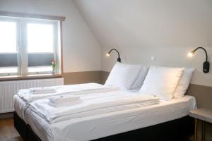 a bedroom with a bed with white sheets and a window at Giethoorn Old Art Hotel in Giethoorn