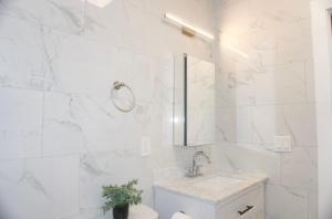 a white bathroom with a sink and a toilet at Master room w private bathroom 23 in Guttenberg