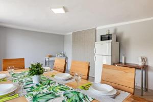 a dining room with a table and a white refrigerator at Family Retreat with Pool, BBQ & Green Escape by Destination GREEN Croatia in Praporčan