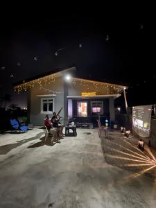 two people sitting in chairs in front of a building at night at Lemery farmbeach Escape in Lemery
