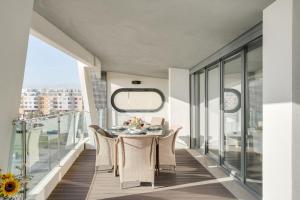 a dining room with a table and chairs on a balcony at luxury Plazza Sea view in Costa da Caparica