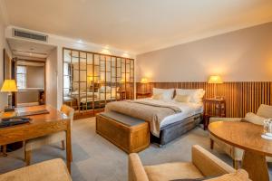 a bedroom with a bed and a living room at St Michael's Manor Hotel - St Albans in St. Albans