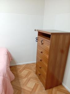 a bedroom with a wooden dresser and a bed at Casa un rincón acogedor in Temuco