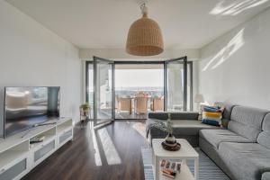 a living room with a couch and a flat screen tv at luxury Plazza Sea view in Costa da Caparica