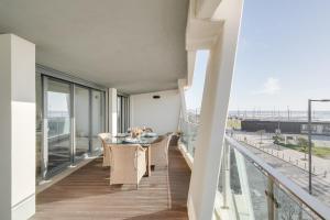 a balcony with a table and chairs on it at luxury Plazza Sea view in Costa da Caparica