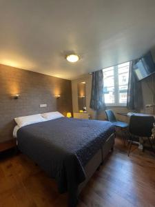 a bedroom with a large bed and a desk at Hotel Les Arcades - La-Roche-en-Ardenne in La-Roche-en-Ardenne
