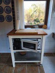 a kitchen island with a microwave on top of it at Lugnt gästhus nära hav, natur och vandring in Glumslöv