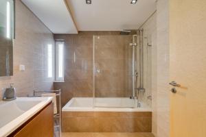 a bathroom with a shower and a tub and a sink at luxury Plazza Sea view in Costa da Caparica +51 photos