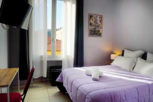 a bedroom with a bed and a desk and a window at Hôtel Claridge's in Menton