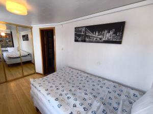 a bedroom with a bed and a picture on the wall at Lugnt gästhus nära hav, natur och vandring in Glumslöv