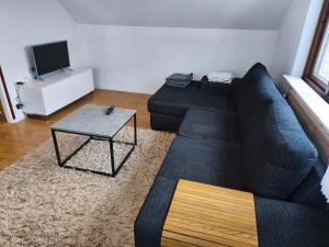a living room with a blue couch and a table at Lugnt gästhus nära hav, natur och vandring in Glumslöv