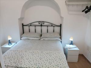 a bedroom with a bed and two lamps on tables at Il sottano borgo antico in Bari