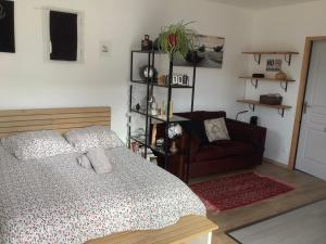 a bedroom with a bed and a couch at Le studio de St Martin in Saint-Martin-de-lʼArçon