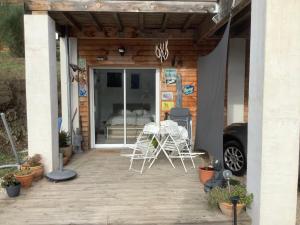a patio with two chairs and a table on it at Le studio de St Martin in Saint-Martin-de-lʼArçon +4 photos