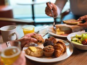 a table with plates of breakfast foods and drinks at B&B HOTEL Inverness in Inverness