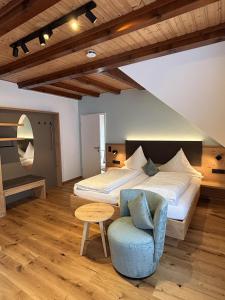 a bedroom with a bed and a blue chair at Landgasthaus zur Linde in Bühl