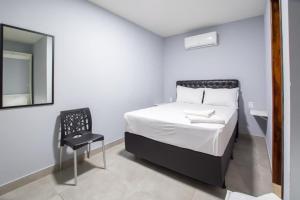 a bedroom with a bed and a chair and a mirror at Pousada Recanto do Sol BF in Baía Formosa +14 photos
