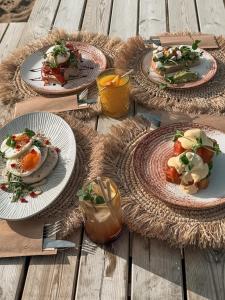 three plates of food on a wooden table at SandCsleep in Katwijk +6 photos