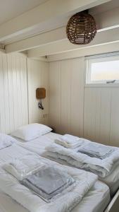 two beds in a room with a window at SandCsleep in Katwijk