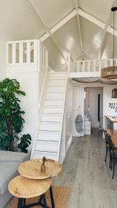 a room with a white staircase and a table at SandCsleep in Katwijk