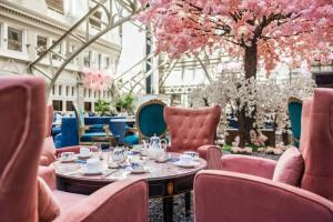 a restaurant with pink chairs and tables and flowers at Waldorf Astoria Washington DC in Washington, D.C.