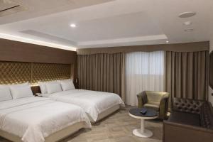 a hotel room with two beds and a chair at Zenith Tourist Hotel in Bucheon +14 photos