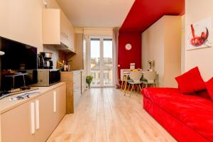 a living room with a red couch and a kitchen at Casa Vino - Gardagate in Salò