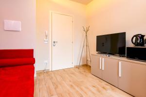 a living room with a red couch and a flat screen tv at Casa Vino - Gardagate in Salò