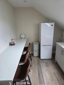 a kitchen with a white counter and a refrigerator at Sheehan's in Bealaclugga