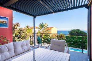 a balcony with a couch and a view of the ocean at MyBlueVista LUXURY SEA VIEW PRIVATE VILLA CAP D AIL 200M MONACO in Cap d'Ail