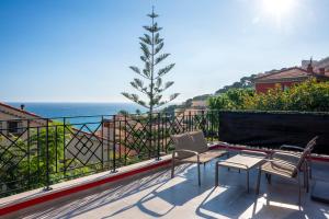 a patio with two chairs and a tree on a balcony at MyBlueVista LUXURY SEA VIEW PRIVATE VILLA CAP D AIL 200M MONACO in Cap d'Ail