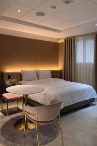 a bedroom with a bed and a table and chairs at Zenith Tourist Hotel in Bucheon
