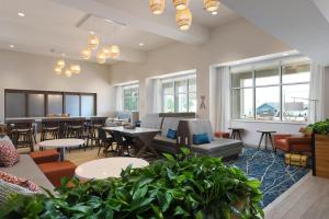 a waiting room with tables and chairs and a cafeteria at Hampton Inn & Suites Manistee, Mi in Manistee