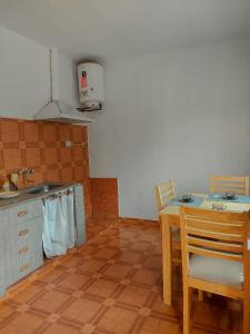 a kitchen with a table and a sink and a table and chairs at Cactus del Valle 2 in Tinogasta