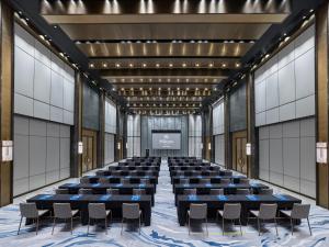 a large room with a stage with chairs and a screen at Hilton Zhuhai in Zhuhai +132 photos