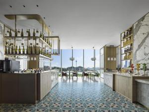 a restaurant with a bar with tables and chairs at Hilton Zhuhai in Zhuhai