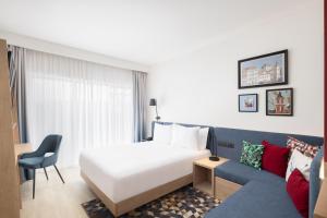 a hotel room with a bed and a couch at Hampton By Hilton Targu Mures in Târgu-Mureş +65 photos