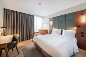 a hotel room with a large bed and a desk at Radisson Blu Hotel, Montpellier in Montpellier