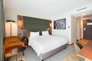 a bedroom with a large white bed and a desk at Radisson Blu Hotel, Montpellier in Montpellier