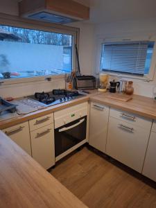 a kitchen with a stove and a window in it at Bateau Escapade in Ramonville-Saint-Agne