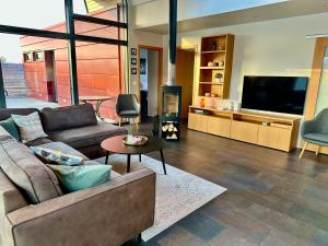 ein Wohnzimmer mit Sofa und Flachbildfernseher in der Unterkunft Nes in Bifrost