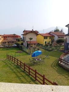 a table with a blue umbrella in a yard at Piccola Luna in Menaggio