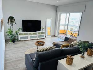 a living room with a couch and a flat screen tv at Rocha Atlantico in Portimão