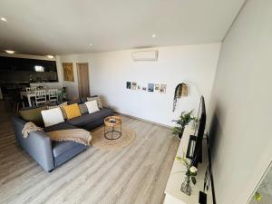 a living room with a couch and a tv at Rocha Atlantico in Portimão